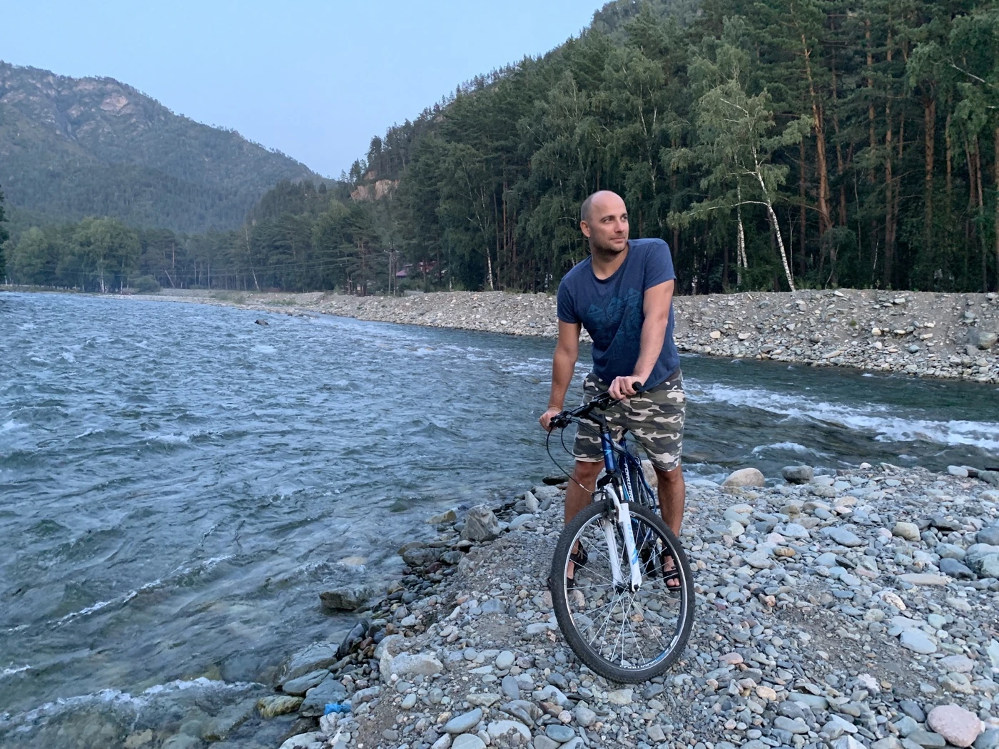 Max Cheprasov with a bicycle beside a mountain river